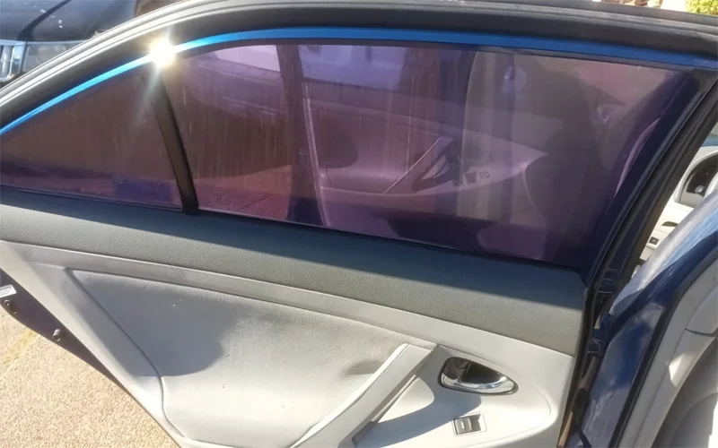 Rear and side window tint removal on a 2010 Toyota Camry showing clear glass after removing purple, bubbled tint — Black Shield Tint.