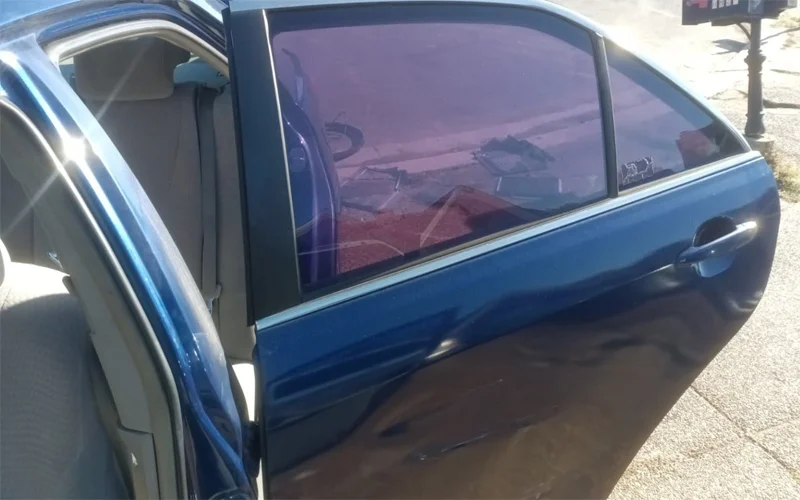 Rear and side window tint removal on a 2010 Toyota Camry showing clear glass after removing purple, bubbled tint — Black Shield Tint.