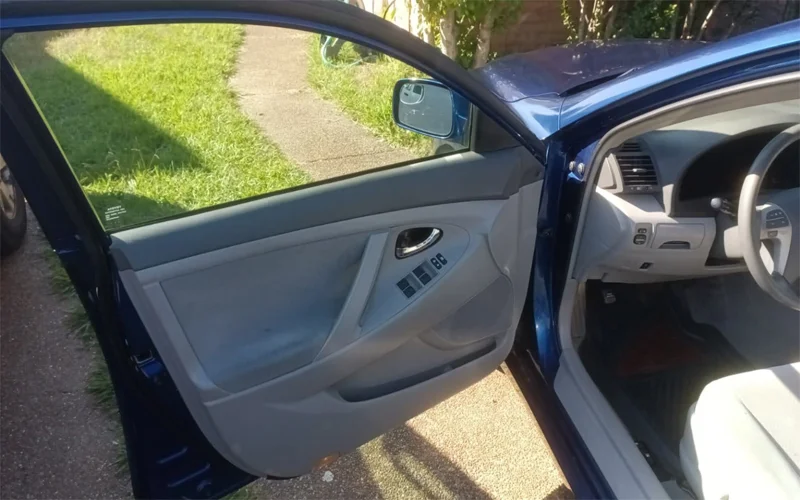 Rear and side window tint removal on a 2010 Toyota Camry showing clear glass after removing purple, bubbled tint — Black Shield Tint.