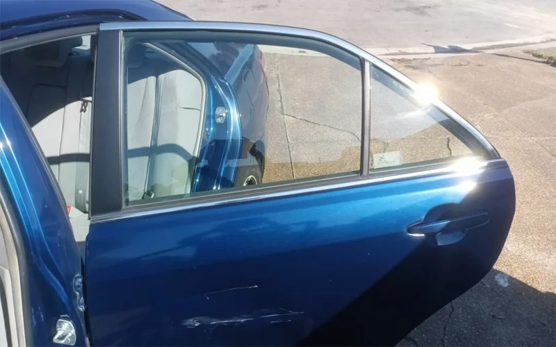 Rear and side window tint removal on a 2010 Toyota Camry showing clear glass after removing purple, bubbled tint — Black Shield Tint.