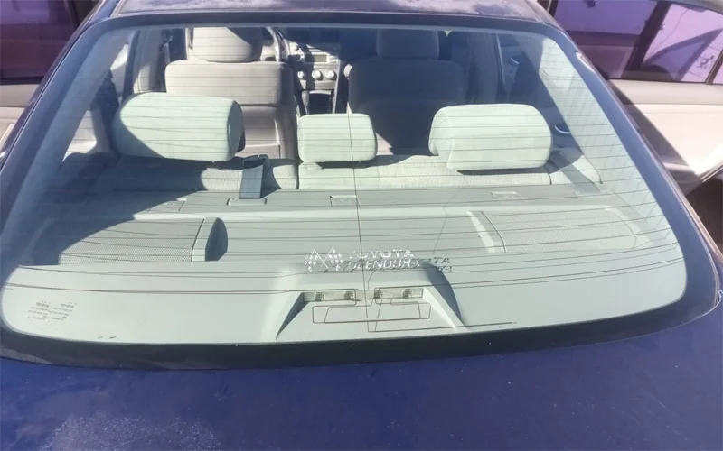 Rear and side window tint removal on a 2010 Toyota Camry showing clear glass after removing purple, bubbled tint — Black Shield Tint.